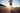 A runner sprinting on an outdoor track at dawn, focus on shoes hitting the ground, dynamic motion blur, warm sunlight behind the athlete, breathable technical clothing, professional sports photography, realistic detail and dust particles, 1:1 aspect ratio.